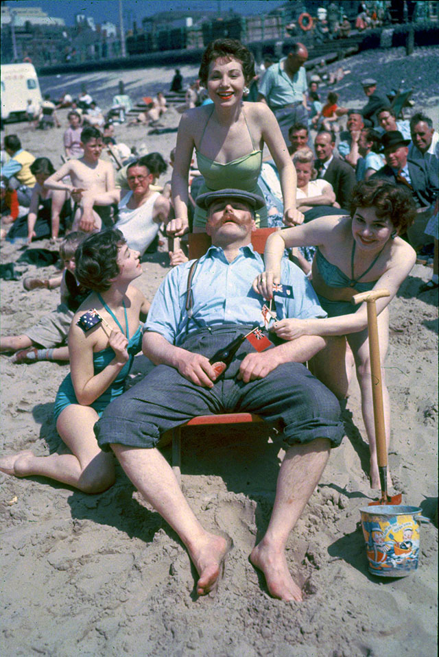 Comedian Jimmy Edwards (1920 - 1988) surrounded by Tiller girls as he relaxes in a deckchair on the beach at Blackpool. They are all appearing in a show on the pier for the summer season.   (Photo by John Chillingworth/Getty Images)